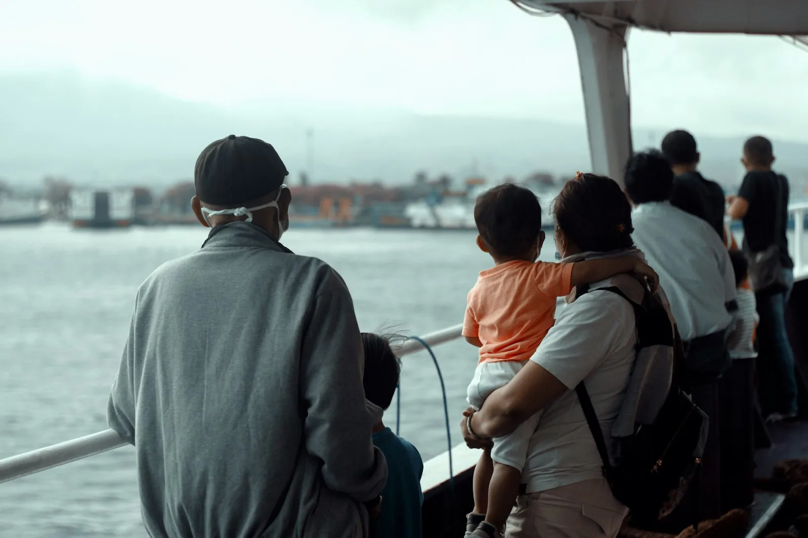 man in gray hoodie standing beside woman in orange jacket
